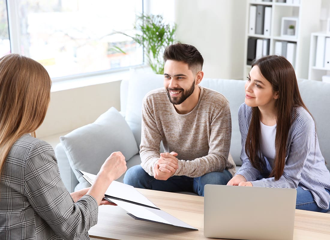 Contact - Friendly Couple and Agent Sit Down Together To Review Documents